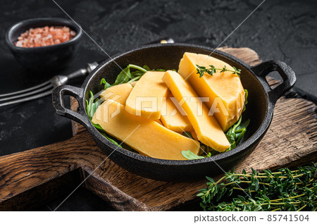 Halloumi cheese in pan ready for grilling. Black background. Top view 85741504