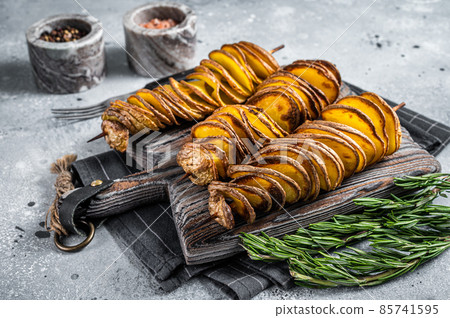 Crispy Tornado or twist potatoes chips on wooden board. Gray background. Top view Crispy Tornado or twist potatoes chips on wooden board. Gray background. Top view 85741595