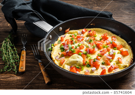 Healthy breakfast food, Stuffed egg omelet with vegetables in a skelet. Wooden background. Top view 85741604