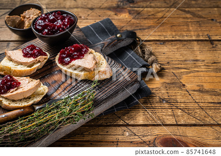French cuisine Foie gras toasts, goose liver pate and lingonberry marmalade. wooden background. Top view. Copy space 85741648