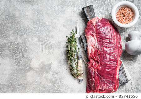 Fresh Flank or flap raw beef steak on wooden board with herbs. Gray background. Top view. Copy space Fresh Flank or flap raw beef steak on wooden board with herbs. Gray background. Top view. Copy space 85741650