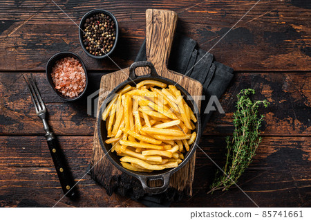 Skilet full of Potato french fries with salt. Wooden background. Top view Skilet full of Potato french fries with salt. Wooden background. Top view 85741661