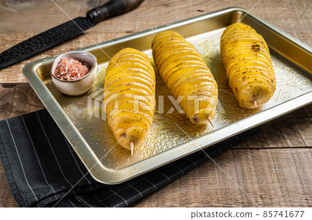Uncooked raw Tornado or Twist potato fries. Wooden background. Top view 85741677