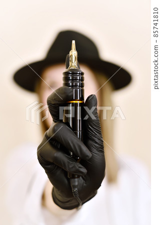Woman hand holding tattoo machine 85741810