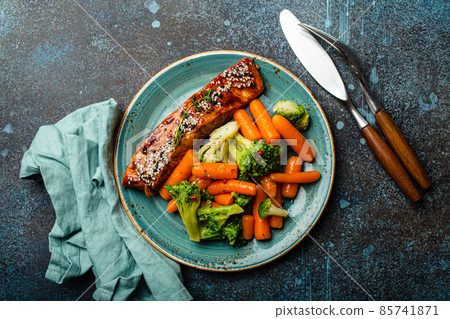 Grilled salmon fillet steak in teriyaki sauce with roasted vegetables carrot and broccoli 85741871