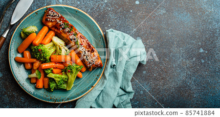 Grilled salmon fillet steak in teriyaki sauce with roasted vegetables carrot and broccoli 85741884