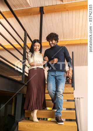 Man and woman looking at steps walking down stairs Man and woman looking at steps walking down stairs 85742385