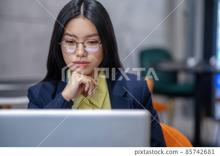 Asian business woman in the office working on a laptop Asian business woman in the office working on a laptop 85742681