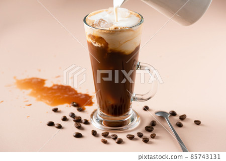 Pouring milk in ice coffee Pouring milk in ice coffee 85743131