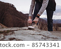 Man ties sneakers walking in the mountains 85743341