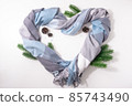 Heart is made of cashmere scarf with fir branches and cones 85743490
