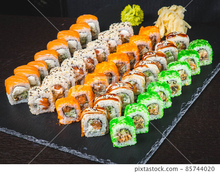 Delicious asian food, roll, sushi and gunkan set. Traditional japanese cuisine restaurant menu assortment. Oriental culinary, eastern cooking. Tasty appetizers on wooden platter and chopsticks 85744020