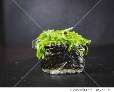 Japanese Cuisine. Pair of Traditional Sushi Rolls With Green Sea Algae Together on Black Reflective Surface.Horizontal Image 85744039