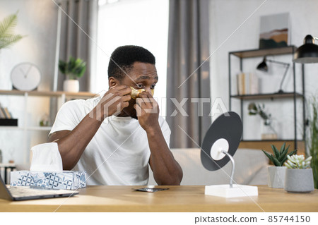 Sporty happy African guy applying golden patches under his eyes 85744150