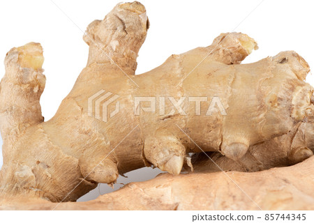 Closeup of fragrant unpeeled ginger root on a white background. Closeup of fragrant unpeeled ginger root on a white background. 85744345