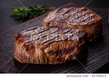 Fresh juicy delicious beef steak on a dark background 85744415