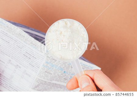 Close-up scoop protein powder in woman's hand 85744655