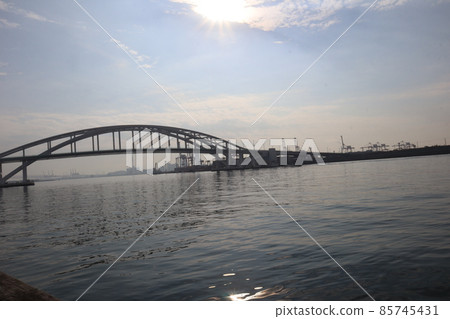 艷陽高照、藍天白雲、拱橋、水面照耀的海、鶴等港灣風光。 艷陽高照、藍天白雲、拱橋、水面照耀的海、鶴等港灣風光。 85745431