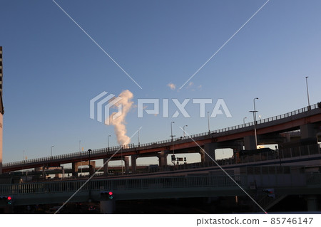 藍天、白煙、高速公路、人行天橋和紅燈的城市景觀 85746147