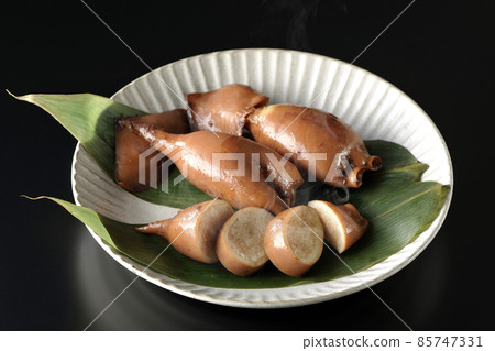 一張新鮮製作的魷魚飯在竹葉上的照片,這是一道當地菜,黑色背景 一張新鮮製作的魷魚飯在竹葉上的照片,這是一道當地菜,黑色背景 85747331