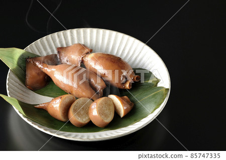 一張新鮮製作的魷魚飯在竹葉上的照片，這是一道當地菜，黑色背景 85747335