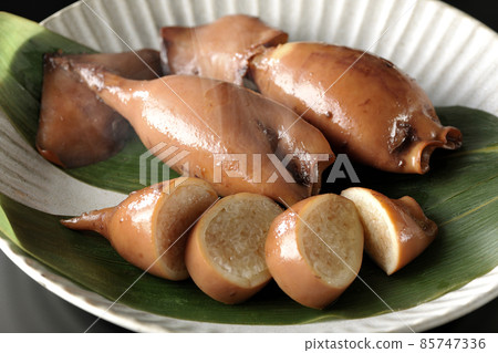 一張新鮮製作的魷魚飯在竹葉上的照片，這是一道當地菜，黑色背景 85747336