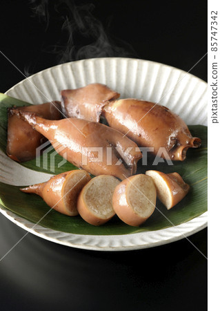 一張新鮮製作的魷魚飯在竹葉上的照片,這是一道當地菜,黑色背景 一張新鮮製作的魷魚飯在竹葉上的照片,這是一道當地菜,黑色背景 85747342