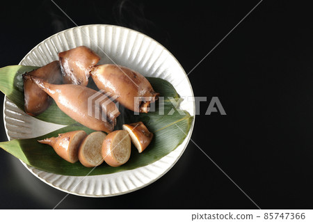 A bird's-eye view of freshly made squid rice on a bamboo leaf with a black background 85747366