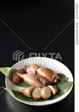 一張新鮮製作的魷魚飯在竹葉上的照片,這是一道當地菜,黑色背景 一張新鮮製作的魷魚飯在竹葉上的照片,這是一道當地菜,黑色背景 85747409