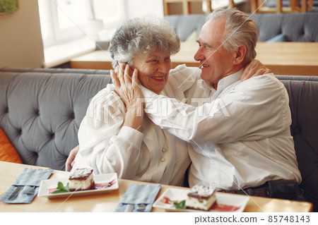Beautiful old couple sitting in a cafe Beautiful old couple sitting in a cafe 85748143