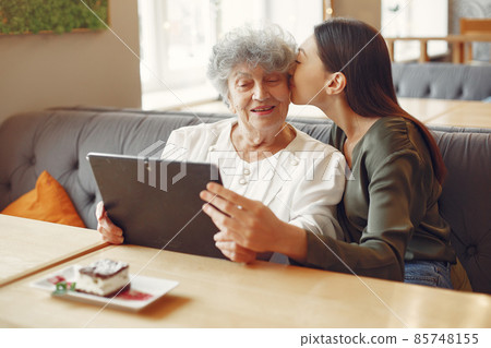 Girl teaching her grandmother how to use a tablet Girl teaching her grandmother how to use a tablet 85748155