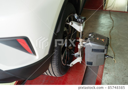 car wheel alignment in progress at auto repair station 85748385
