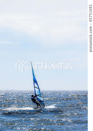 Windsurfing around the water in the refreshing breeze Windsurfing around the water in the refreshing breeze 85751081
