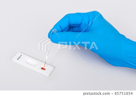 scientist or doctor hand placing blood sample on Rapid Diagnostic test cassette quick fast blood testing identifying antibodies for COVID-19 Coronavirus is on white background 85751854
