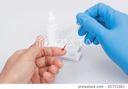 Doctor making Coronavirus COVID-19 quick Rapid Diagnostic Test RDT, Scientist worker place collected patient finger prick blood sample specimen on cassette, COVID-19 antigen rapid test concept 85751861