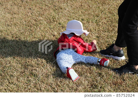 一個一歲的孩子在草坪上玩耍時生病了 85752024