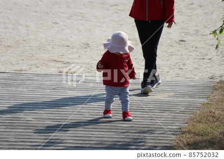 一個 1 歲兒童在沙灘上玩耍的背影 85752032