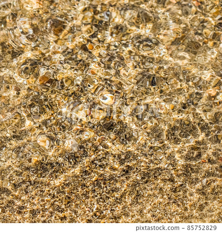 A background of sand, small pebbles and flowing waves on the sea beach. Summer vacation and coastal nature concept A background of sand, small pebbles and flowing waves on the sea beach. Summer vacation and coastal nature concept 85752829