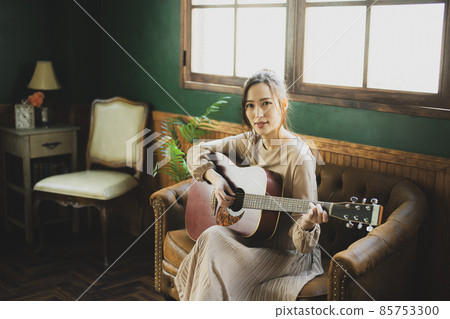 A woman playing the guitar A woman playing the guitar 85753300