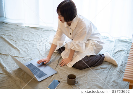 一位女士在房間裡輕鬆的氣氛中看著筆記本電腦 一位女士在房間裡輕鬆的氣氛中看著筆記本電腦 85753692