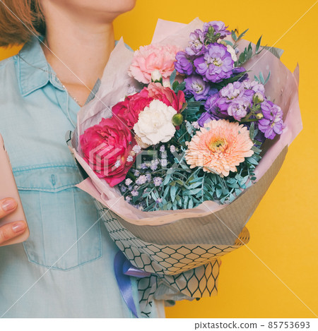 A bouquet of flowers in the hands of a woman A bouquet of flowers in the hands of a woman 85753693