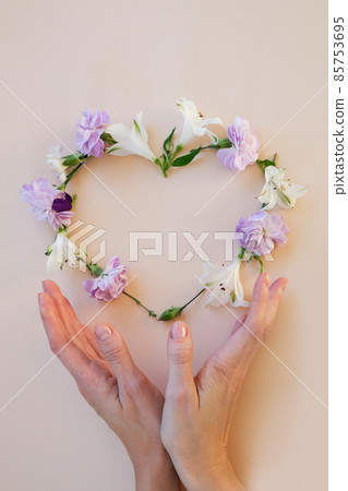 Frame of chamomiles, branches, leaves and petals on beige background. Frame of chamomiles, branches, leaves and petals on beige background. 85753695
