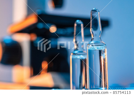 Medical vial with medication near microscope photo 85754113