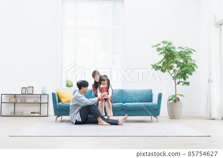 一個在客廳裡放鬆的年輕家庭 85754627