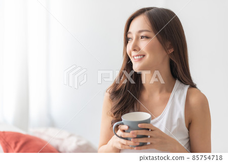 Happy Smiling Asian Young woman relaxing at home in the morning. 85754718