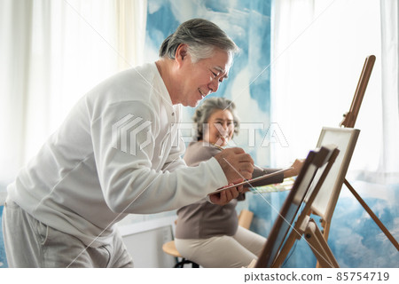 Asian Senior Couple colouring with watercolor together. 85754719