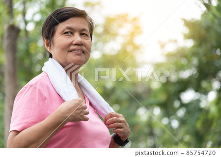Asian smiling sporty senior woman in a park outdoor. 85754720