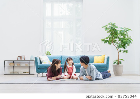 A family of three lying down in the living room 85755044