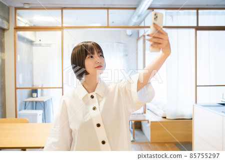 一個女人在室內拿著智能手機 一個女人在室內拿著智能手機 85755297