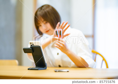 A woman using a smartphone to introduce cosmetic goods 85755876